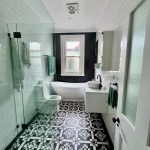 Bathroom repaint in Drummoyne with white walls, black feature wall and tiled floor
