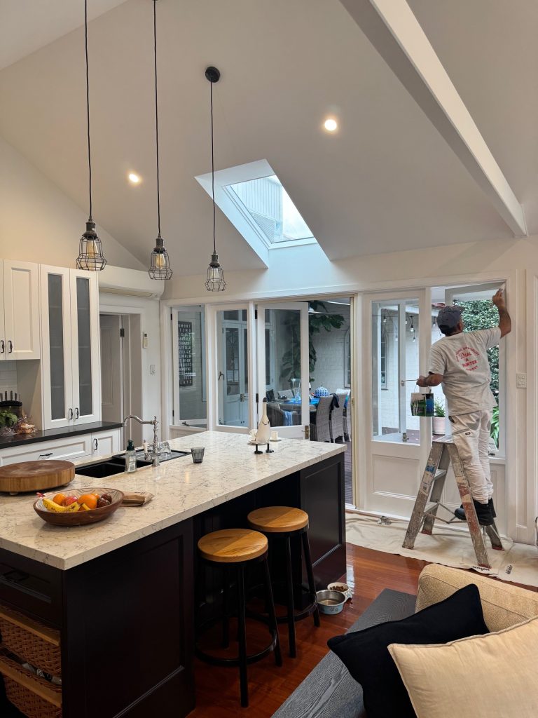 Interior painting in Drummoyne kitchen extension with painter working on doors and trim