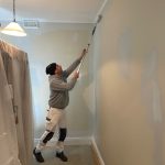 Interior painter in Dulwich Hill applying paint to wall using extension roller during preparation stage