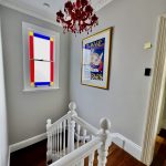 Upper stair landing painting with feature lighting and stained glass window in Enmore home