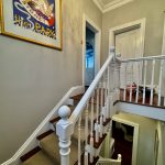 Upper staircase landing painting with decorative ceiling and feature lighting in Enmore home