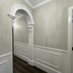 Hallway interior in Ashbury home with decorative archway, wall panelling and detailed paint finishes