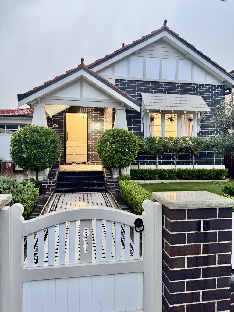 Front exterior of a character-style home in Ashbury with painted gables, stained glass windows and detailed exterior finishes