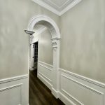 Interior hallway with decorative archway, wall panelling and detailed trim painting in Ashbury home