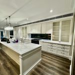 Custom kitchen in Ashbury home with painted cabinetry, detailed trim and bright interior finishes