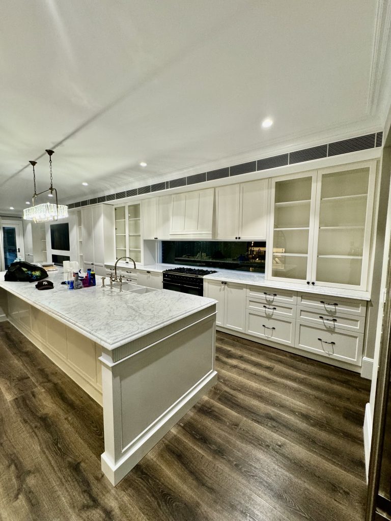 Custom kitchen in Ashbury home with painted cabinetry, detailed trim and bright interior finishes