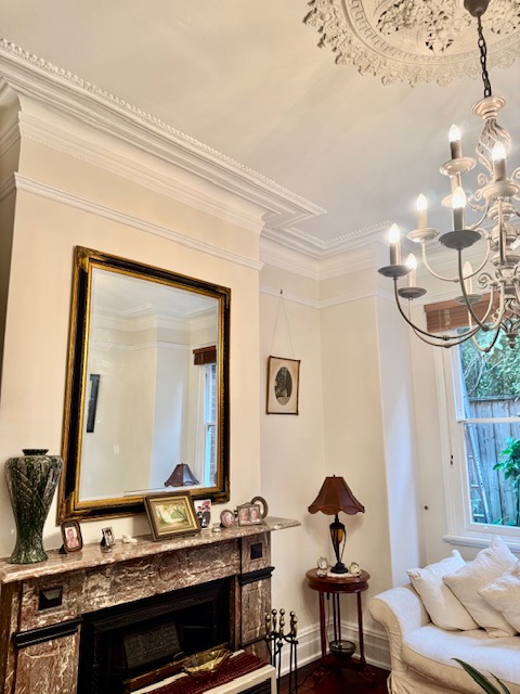 Heritage living room with neutral walls, ornate ceiling and original marble fireplace