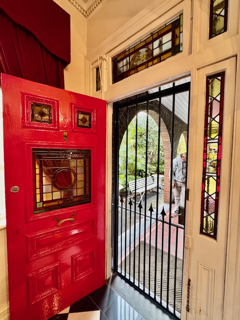 Red heritage front door with original stained glass panels in a Sydney home