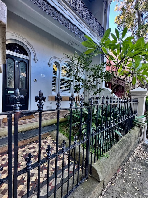 Victorian terrace exterior with heritage colours, ironwork and tessellated tile path